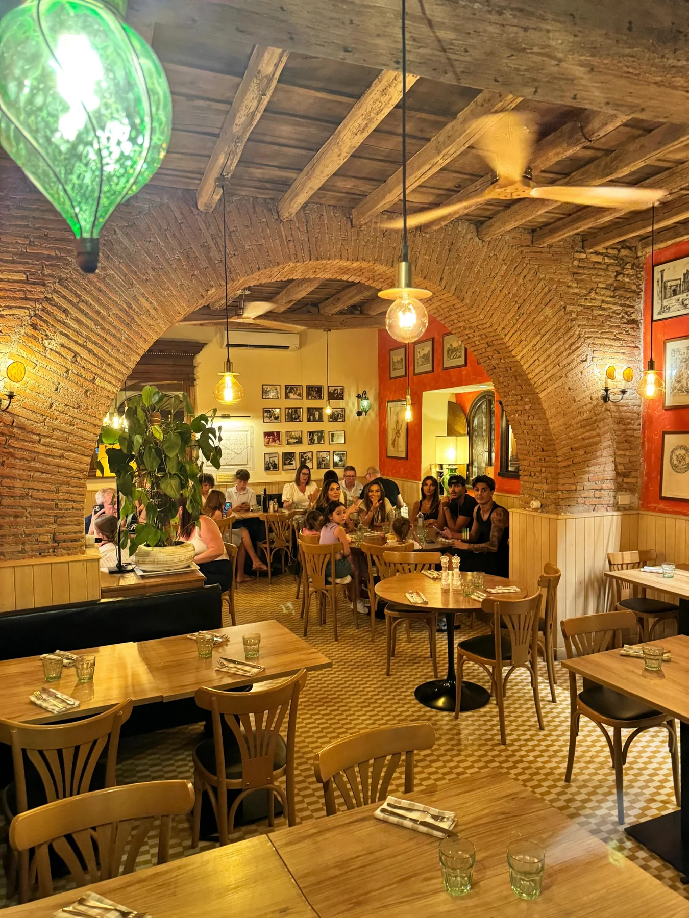 Sala interna con grandi archi in mattoni e tavoli in legno